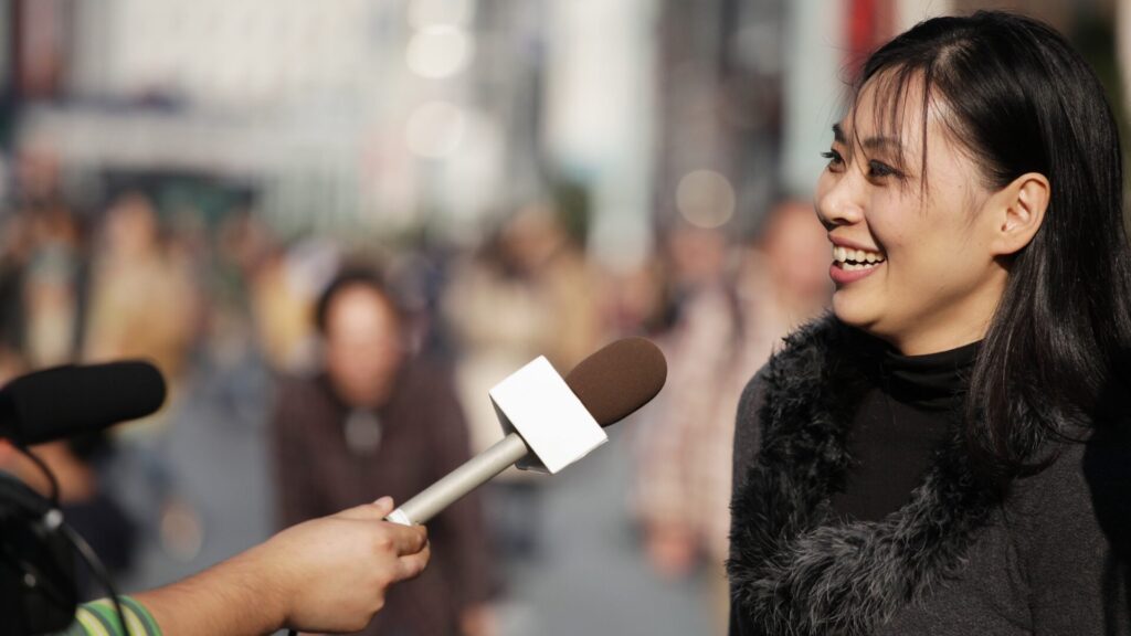 女性が街中でインタビューを受けている