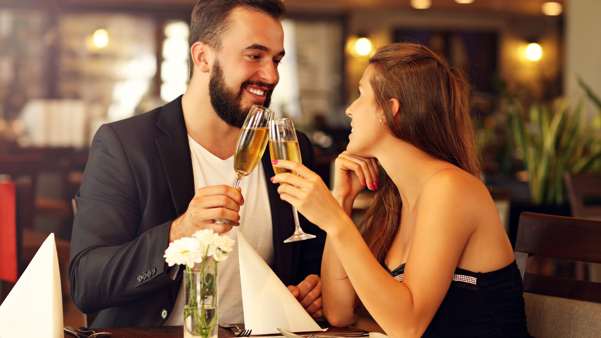 正装の男女がグラスに継がれたお酒で乾杯している
