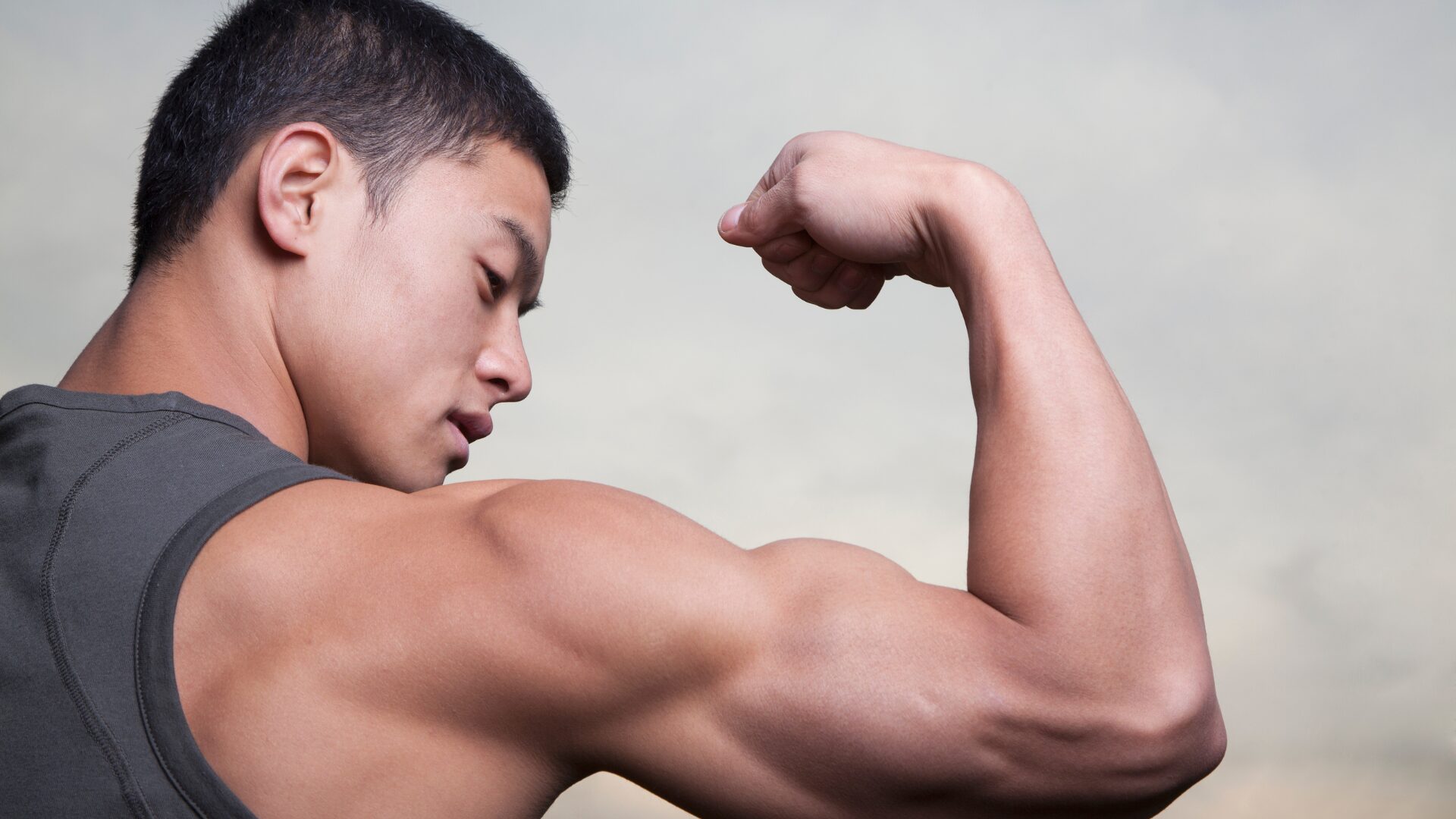 男性がガッツポーズの姿で筋肉を見せている