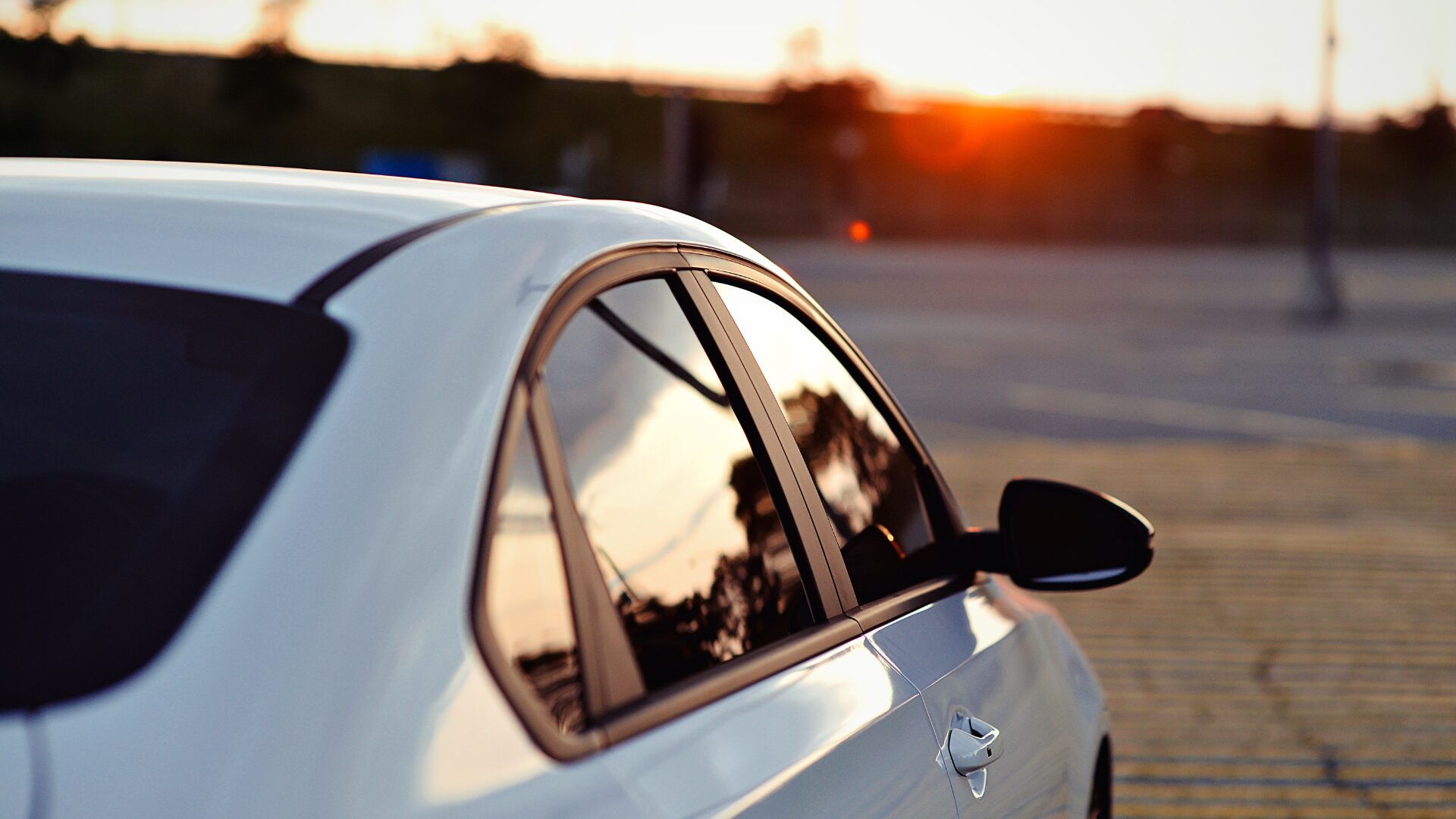 白い車の向こう側から夕陽がさしている