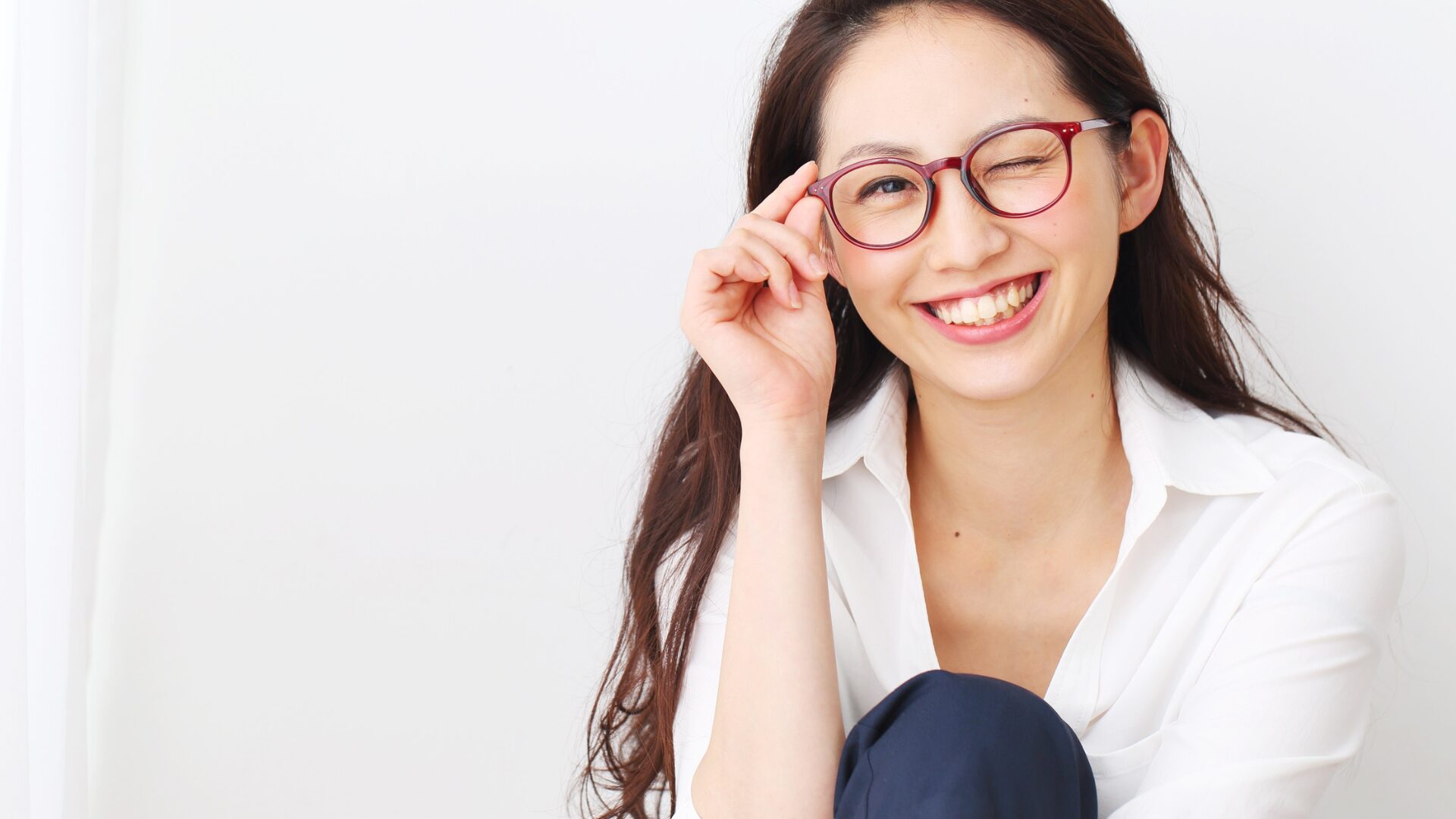 メガネをかけた女性がこちらにウインクしている