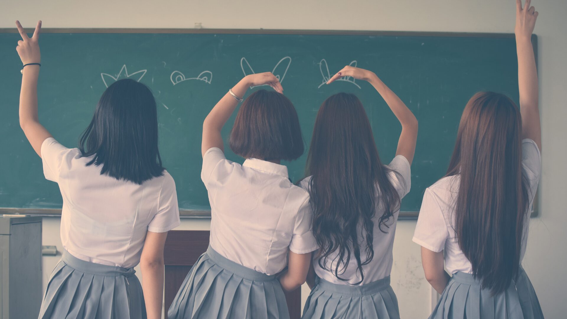 背中を向けた４人の女性がそれぞれにポーズをとっている