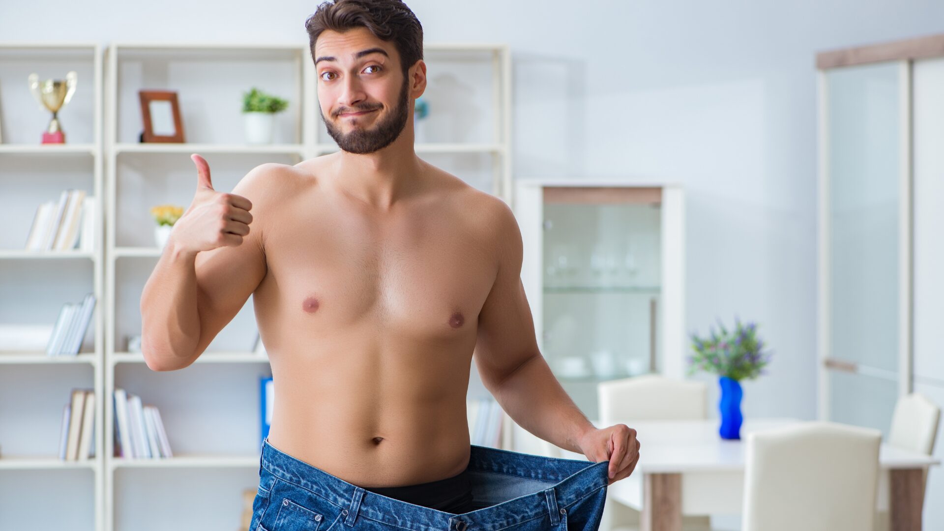 男性がブカブカのお腹周りの大きいズボンを引っ張ってダイエットできたことを喜んでいる