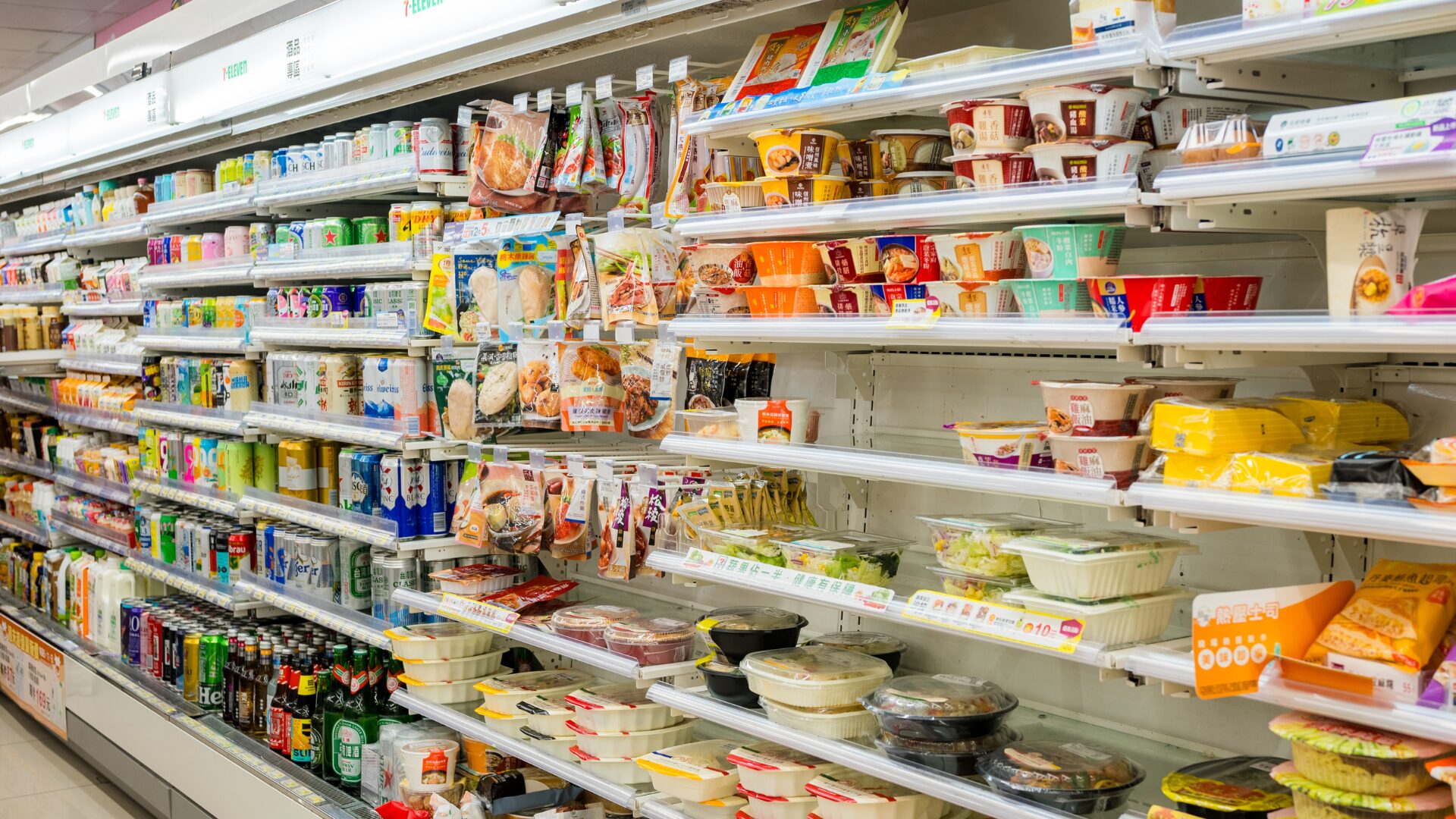 コンビニの陳列棚に商品がたくさん並んでいる